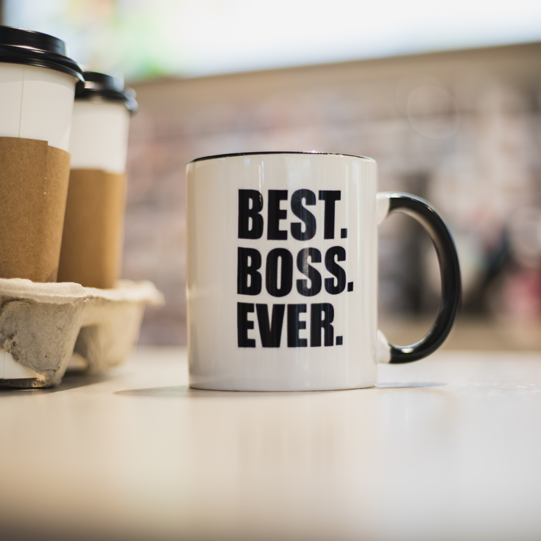 coffee mug on counter that reads Best Boss Ever sitting beside tray with 2 cups of takeout coffee