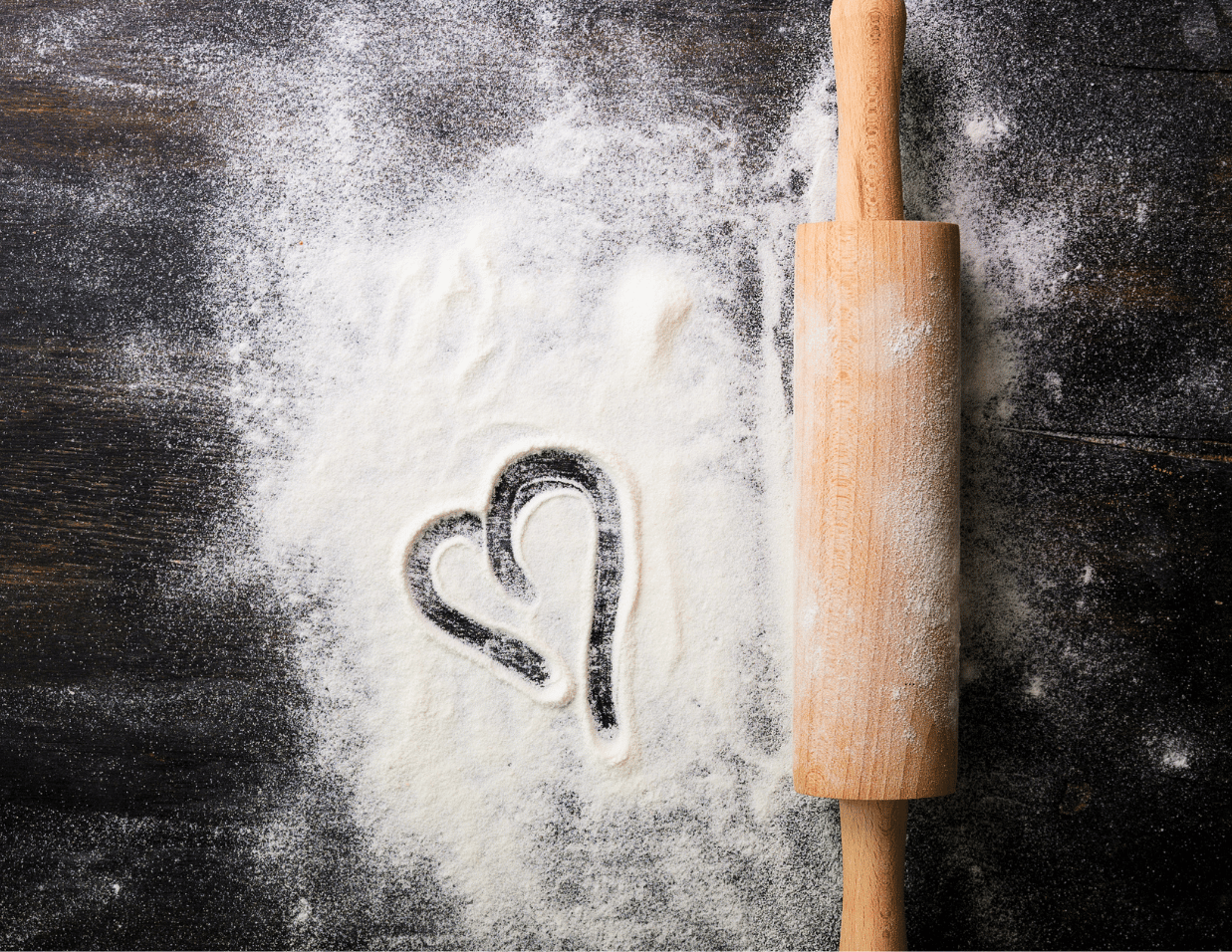 bench with flour and rolling pin. Heart shape etched into the flour 