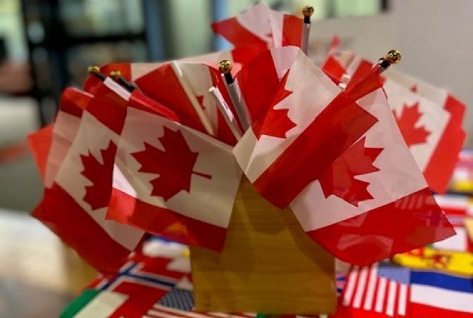 a table covered with a tablecloth that has international flags as the design on it. Glass windows with lights on in the background