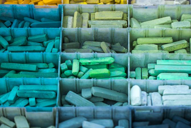 a divided container holding many colours of sidewalk chalk