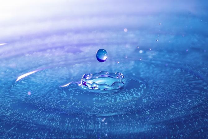 photo of a drop of water and the ripples on the surface